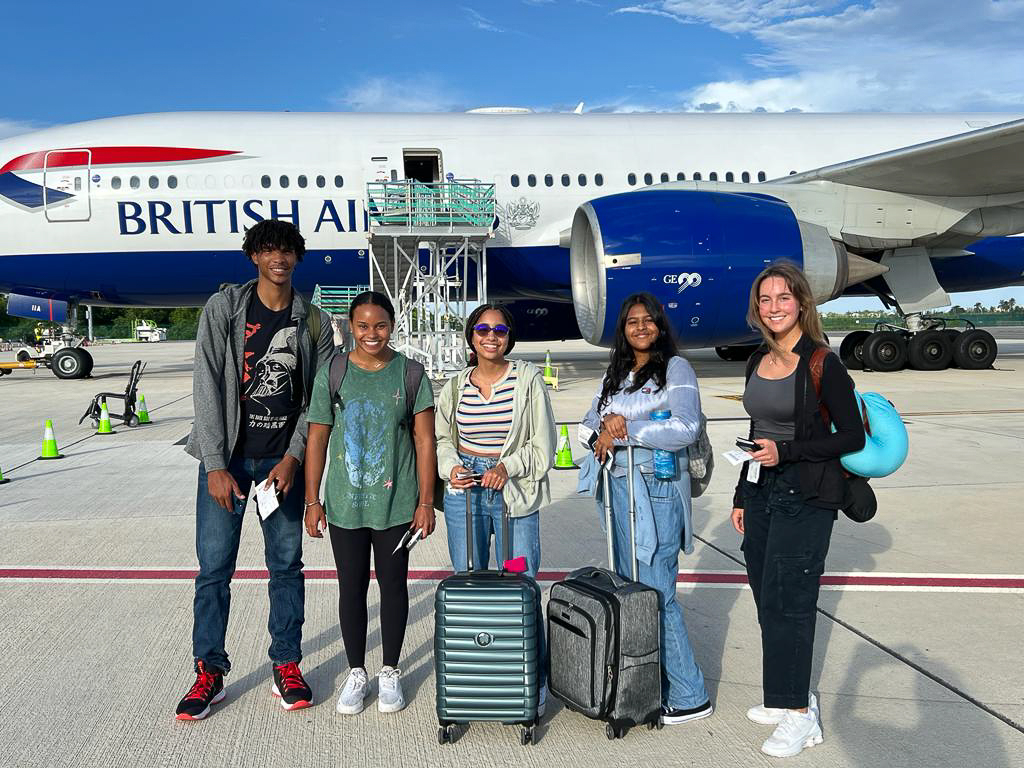 students and teacher in front of British Airways plane
